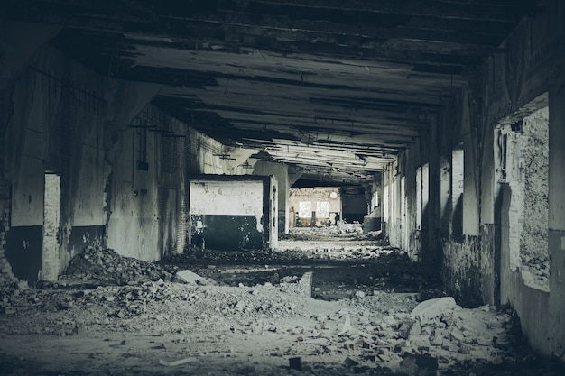 Interior del edificio abandonado, oscuro corredor aterrador espeluznante en locales abandonados en ruinas rotas sucias de época, ruinas de la antigua fábrica industrial, fondo urbano sucio