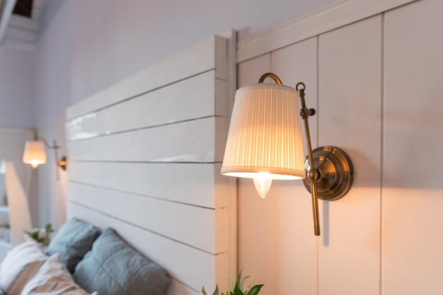 Interior elegante da lâmpada do quarto confortável na parede