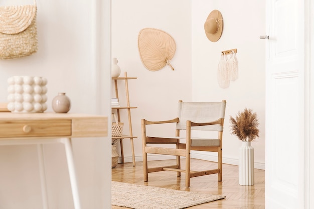 Interior elegante e aconchegante da sala de estar com acessórios de vime, poltrona de design, flores em um vaso e prateleira de madeira. Estilo coreano de decoração para casa.