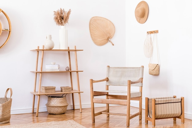 Interior elegante e aconchegante da sala de estar com acessórios de vime, poltrona de design, flores em um vaso e prateleira de madeira. Estilo coreano de decoração para casa.