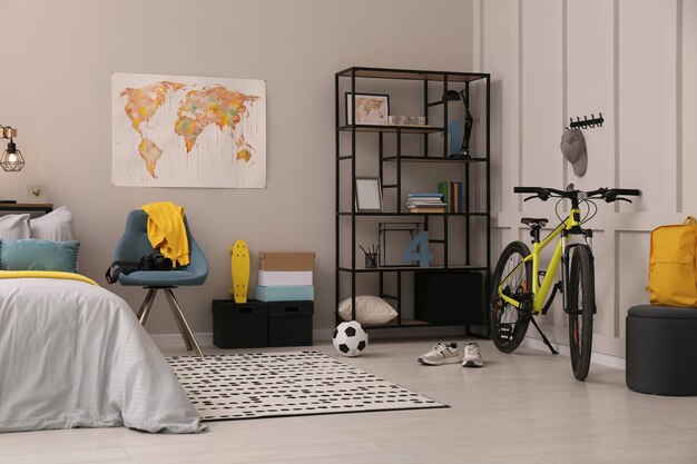 Interior elegante de la habitación de un adolescente con una cama cómoda y equipo deportivo