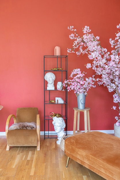 Interior de época antigua en la sala de estar de estilo del siglo XIX con paredes de color rojo brillante, piso de madera y luz solar directa dentro de la habitación.