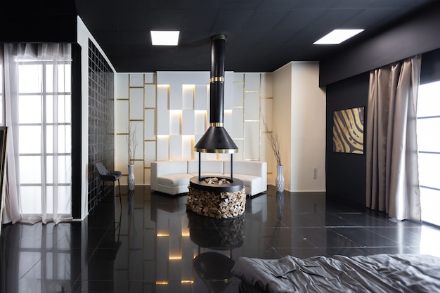 Interior escuro e elegante de apartamento masculino com iluminação, paredes decorativas, lareira, área de vestir e janela enorme
