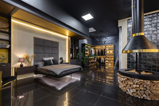Interior escuro e elegante de apartamento masculino com iluminação, paredes decorativas, lareira, área de vestir e janela enorme