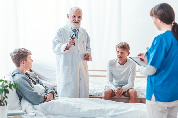 Foto interior espartano de la habitación del hospital en la que se encuentran el médico y los pacientes en las camas