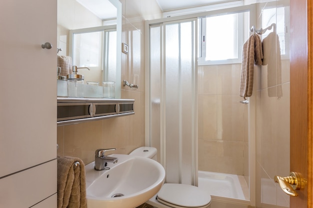 Interior de estilo simple de baño pequeño con paredes de baldosas de cerámica beige lavabo blanco inodoro clásico ...