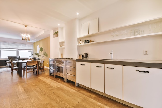 El interior de un estudio con una amplia cocina de estilo minimalista en un suelo de parqué