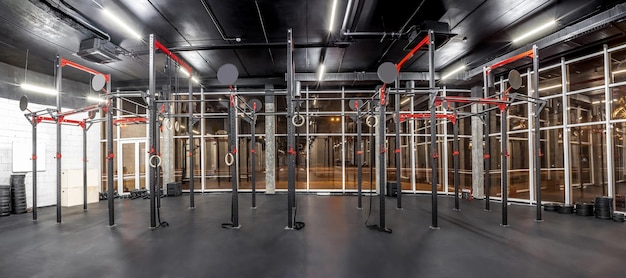 Interior del gimnasio de entrenamiento para crossfit Equipo para entrenamiento de intervalos de alta intensidad en espaciosas habitaciones Barras horizontales anillos de gimnasia Deporte