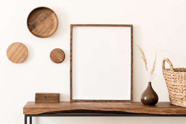 Interior de la habitación creativa y elegante con marco en blanco, consola de madera y accesorios. Paredes blancas. Concepto minimalista.