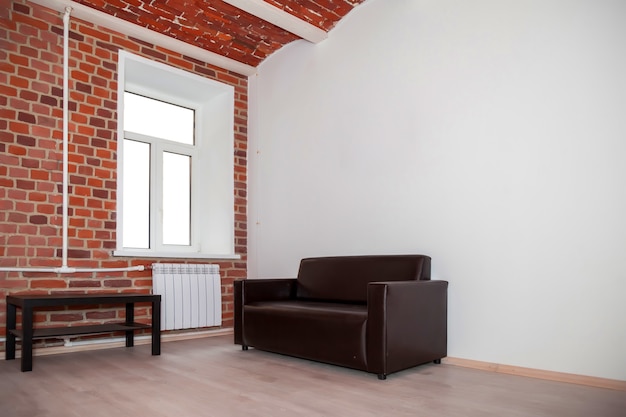 El interior de la habitación está diseñado en estilo loft con muebles y paredes decorativas de ladrillo rojo