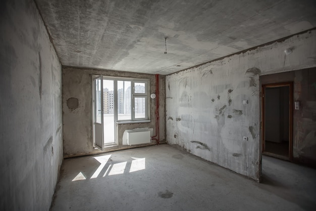 Interior de la habitación de hormigón de paredes vacías. ventana en habitación nueva