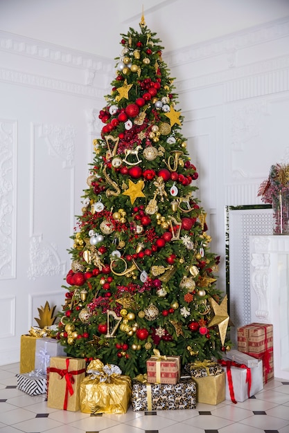 Interior de la habitación de luz con árbol de año nuevo decorado y cajas presentes