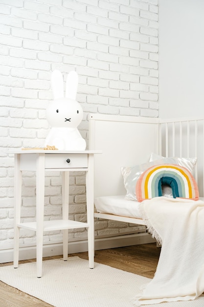 El interior de la habitación de los niños con una cama cómoda y almohada arco iris.