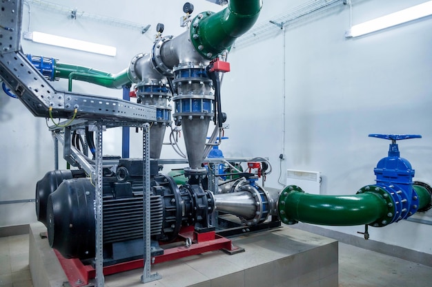 Interior industrial de bomba de agua, válvulas, manómetros, motores dentro de la sala de máquinas. Válvula y bombas en una sala industrial. Tuberías y bombas potentes modernas urbanas, sistemas de control automático