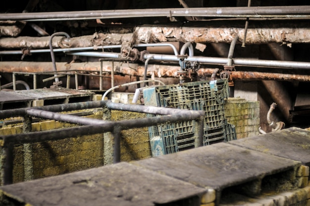 Interior industrial do prédio da antiga fábrica, velha banheira enferrujada de ácido.