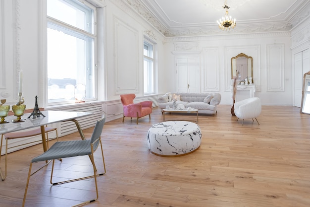 Interior de lujo de estilo barroco muy ligero de gran salón. Paredes blancas decoradas con estuco impresionante. Apartamento de estilo real con muebles elegantes con elementos dorados.