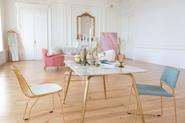 Interior de lujo de estilo barroco muy ligero de gran salón. Paredes blancas decoradas con estuco impresionante. Apartamento de estilo real con muebles elegantes con elementos dorados.