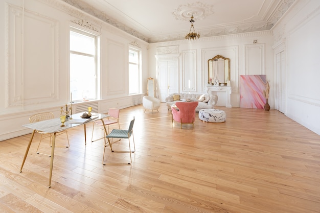 Interior de lujo de estilo barroco muy ligero de gran salón. Paredes blancas decoradas con estuco impresionante. Apartamento de estilo real con muebles elegantes con elementos dorados.