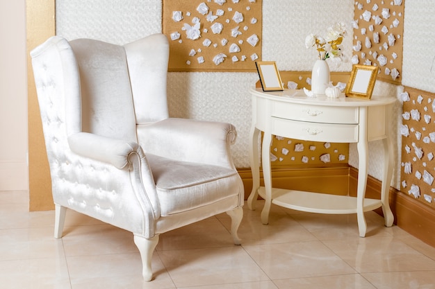 Interior de lujo. Lujoso sillón blanco, muebles antiguos tallados, detalles interiores de habitaciones clásicas.