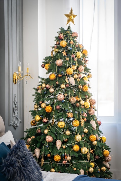 Interior de lujo de sala de estar con árbol de Navidad decorado y regalos en el piso de madera.