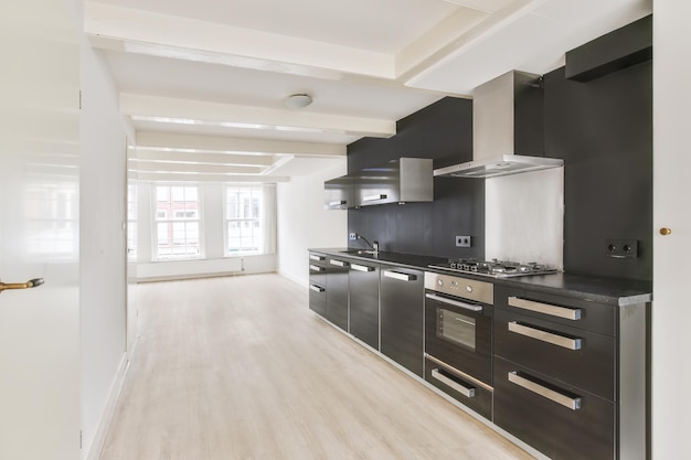 Interior de una luminosa habitación vacía con modernos electrodomésticos de cocina con armarios negros