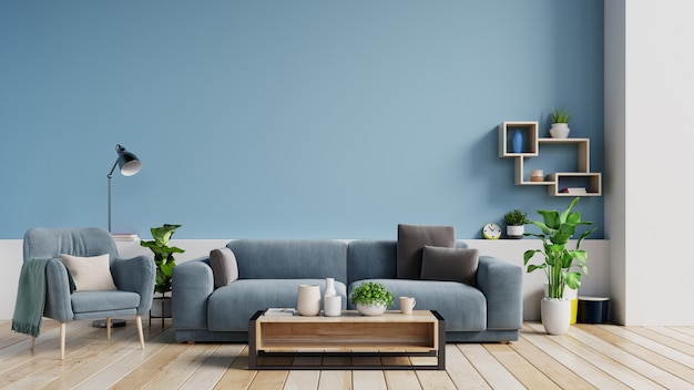 Interior de una luminosa sala de estar con almohadas en un sofá y sillón, plantas y lámpara sobre fondo de pared azul vacía.