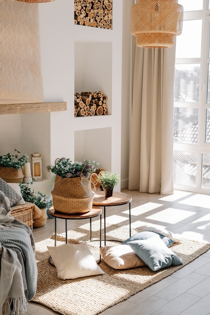 Interior de la luminosa sala de estar en estilo eco escandinavo con mesa de café y almohadas en el piso, gran sombra de la ventana en el piso.