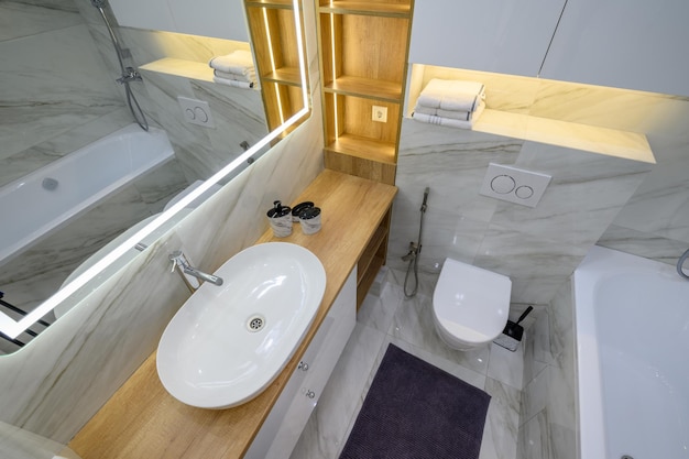Foto interior luxuoso do banheiro com azulejos de mármore nas paredes