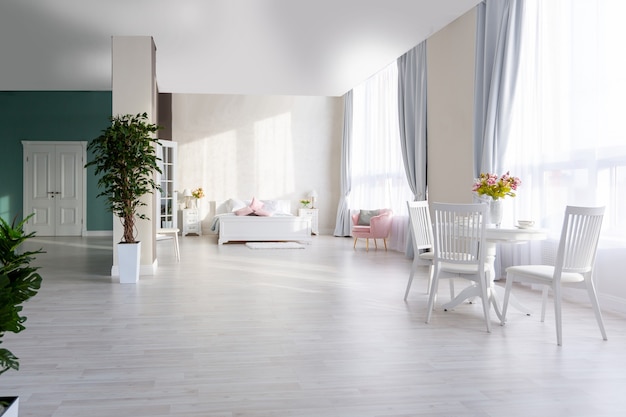 Interior luxuoso e caro de um apartamento de plano aberto em cores claras. quarto moderno e elegante com design minimalista, área para refeições e espaço para hóspedes.