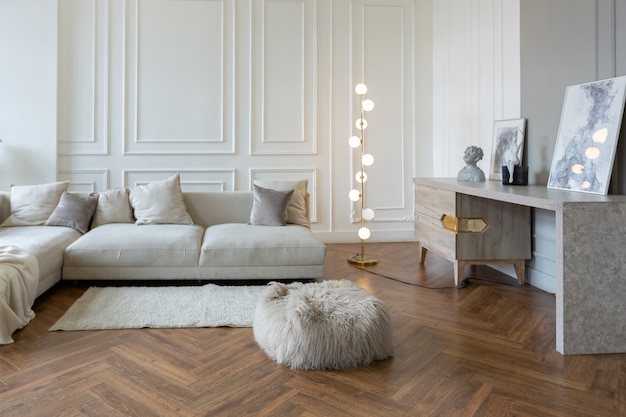 Interior minimalista de un apartamento ultramoderno de planta abierta con paredes blancas y grises con un relieve y muebles tapizados con estilo gris y grandes ventanales