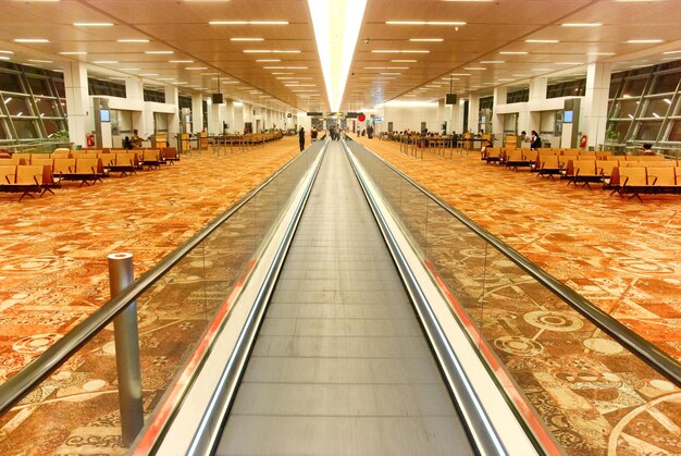 Interior de la moderna sala del aeropuerto con la escalera mecánica plana