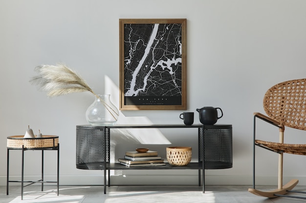 Interior de la moderna sala de estar escandinava con marco de pintura, inodoro de diseño, hoja en jarrón, sillón de ratán, libro y accesorios elegantes en la decoración del hogar con estilo.