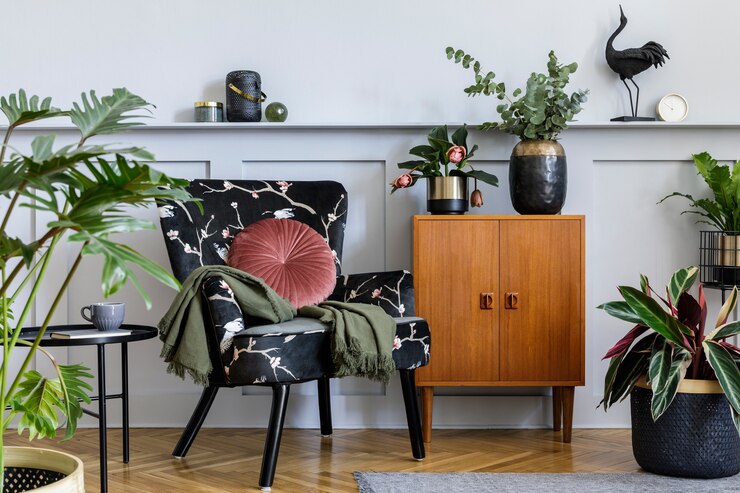 Foto interior moderno da sala de estar com poltrona de design, cômoda vintage de madeira, painéis de madeira com prateleira, muitas plantas, mesa de centro, parede cinza e acessórios personalizados na decoração da casa.