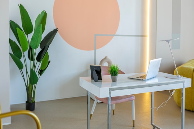 Interior moderno da sala de plano aberto em estilo futurista em cores pastel com decoração de parede gráfica. tectos muito altos e uma janela enorme. móveis macios e elegantes com elementos metálicos dourados