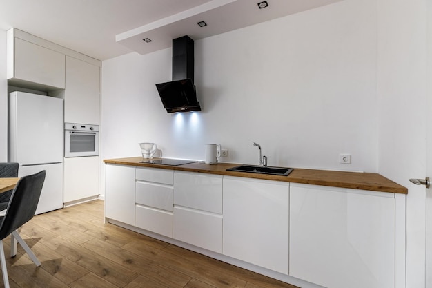Interior moderno de móveis de madeira de cozinha e mesa e cadeiras elegantes Espaço espaçoso e luxuoso em apartamento