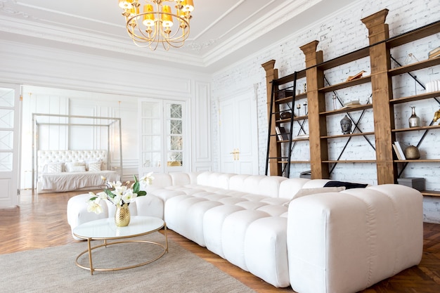 Interior moderno de um luxuoso apartamento amplo e luminoso de dois quartos. paredes brancas, móveis luxuosos e caros, piso de parquete e portas internas brancas