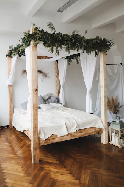 interior moderno do quarto em estilo escandinavo com uma cama aconchegante com dossel de madeira e travesseiros