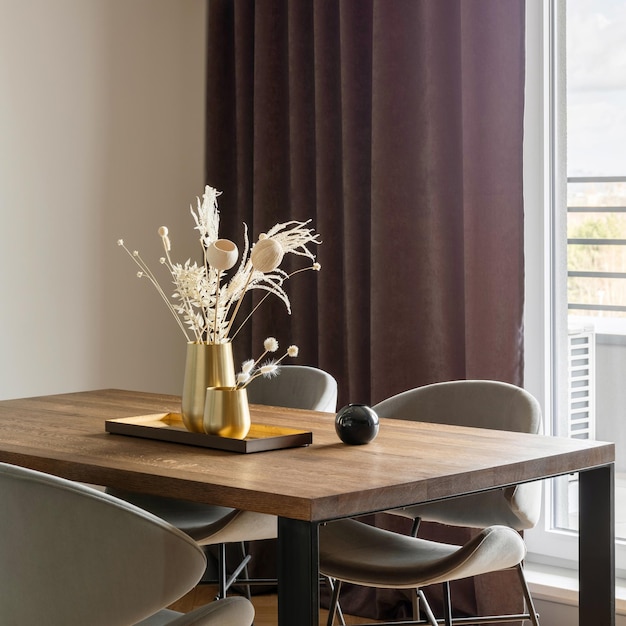 Interior moderno e vintage da sala de jantar com cadeiras cinza de mesa de madeira marrom e lustre elegante