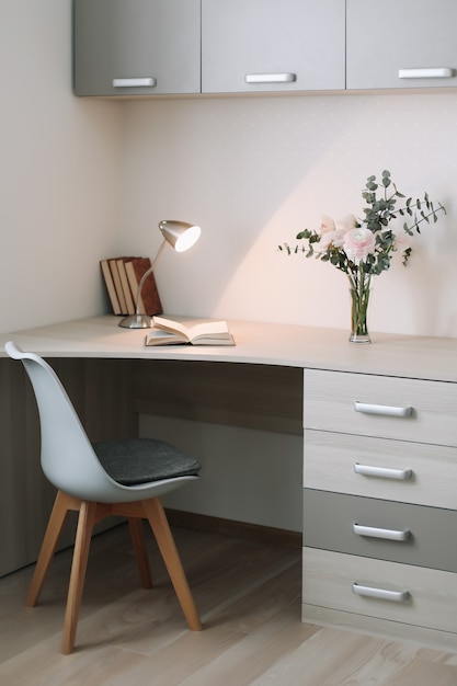 Interior moderno em casa. Mesa de madeira com livros e flores. Conceito de planejamento e design. Ambiente de trabalho. Postura plana feminina.