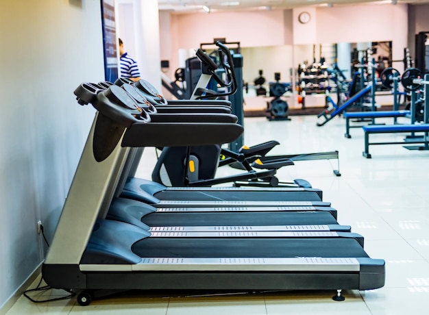 Foto interior moderno ginásio com equipamento fitness club com linha de esteiras para fitness e treinamento cardio conceito de estilo de vida saudável