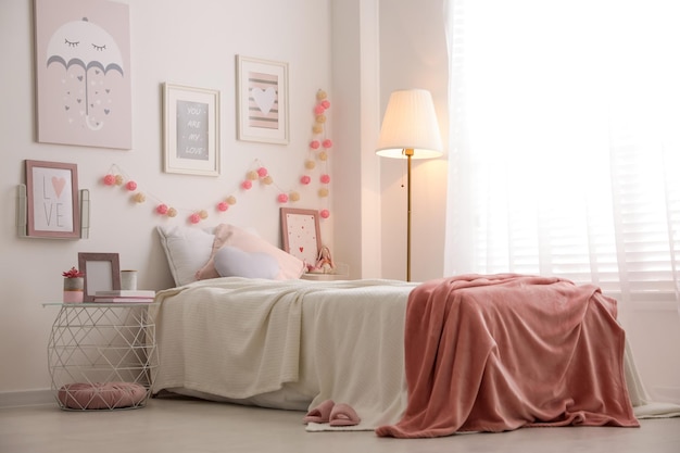 Interior moderno de la habitación de los adolescentes con una cama cómoda y bellas imágenes.