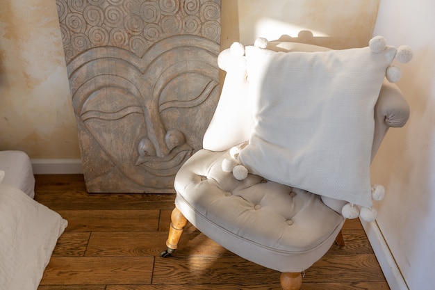 Interior moderno de una habitación luminosa en un apartamento de dos pisos con elementos decorativos en estilo bali con balcón. paredes blancas, pisos de madera y muebles vintage