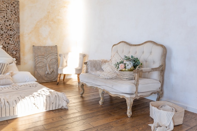 Foto interior moderno de una habitación luminosa en un apartamento de dos pisos con elementos decorativos en estilo bali con balcón. paredes blancas, pisos de madera y muebles vintage