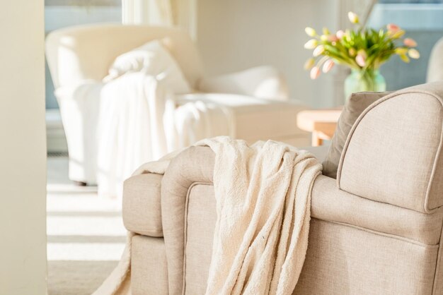 Interior moderno minimalista de la habitación con un sillón blanco y una manta acogedora