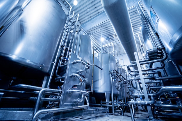 Interior moderno de una planta de bebidas con barriles y tubos