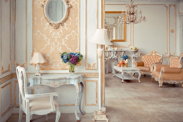 Interior muy rico del apartamento con decoraciones doradas en las paredes en estilo barroco y muebles de lujo con pintura dorada.
