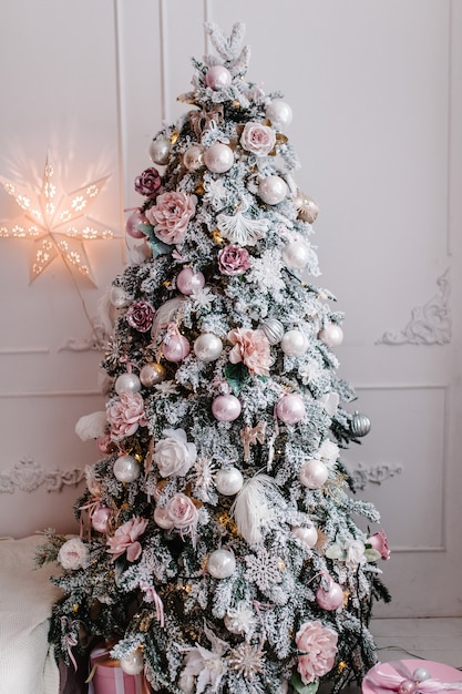 Interior de Navidad decorado. Guirnaldas decoradas con abeto con cajas de regalo en una habitación blanca.