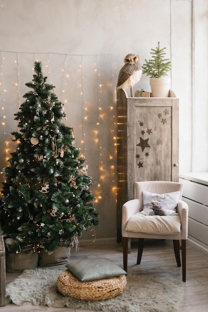 Interior navideño escandinavo decorado con un árbol de Navidad en la habitación de los niños Armario con sillón de juguetes para niños