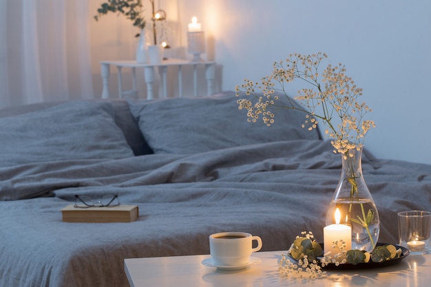 Interior de noche de dormitorio con flores y velas encendidas