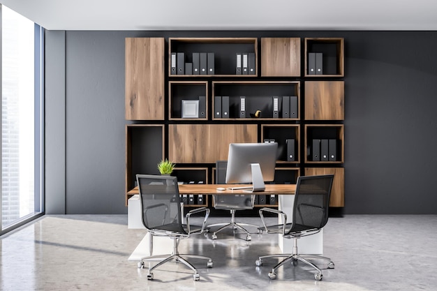 Interior de la oficina del director general con paredes grises, ventanas panorámicas, suelo de hormigón y mesa blanca y de madera con ordenador y sillas negras. Librería de madera clara con carpetas. representación 3d
